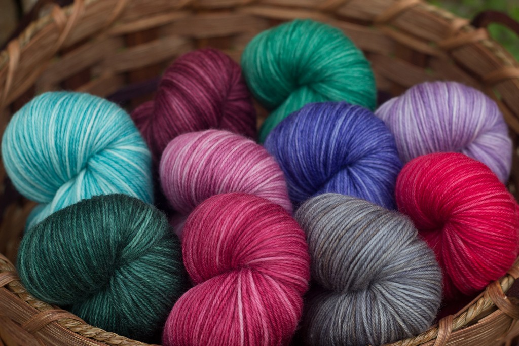 A basket full of Round Table Yarns in the Camelot base, which is a fingering weight MCN.